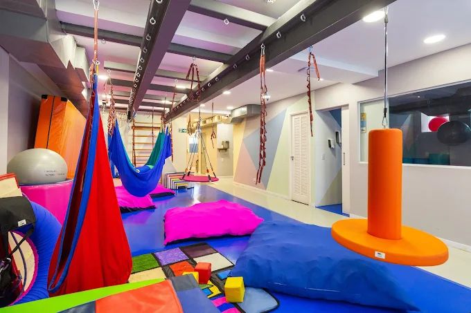 Sala de integração sensorial com balanços e colchões